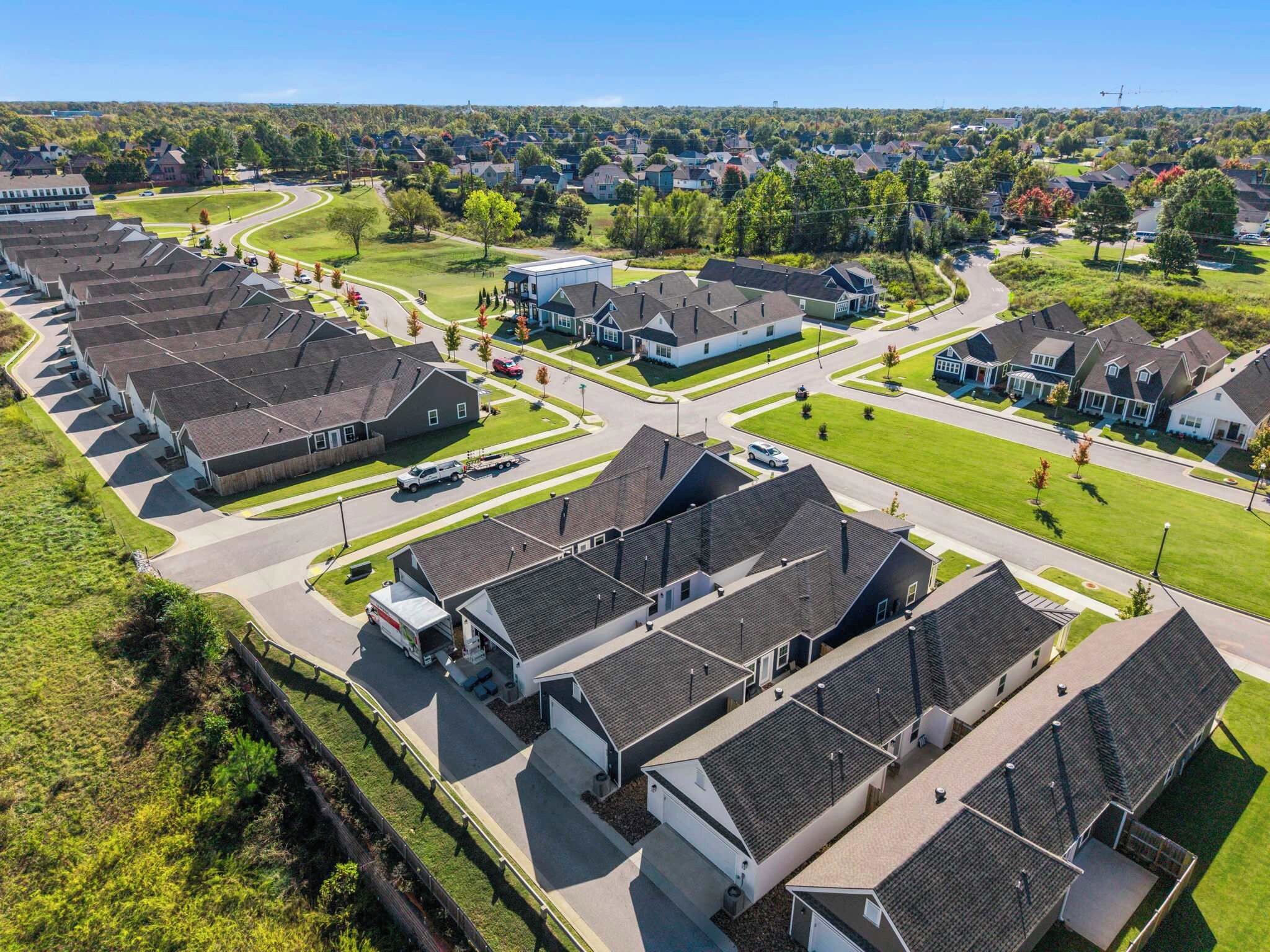 A residential area with modern houses, well-maintained lawns, and a clear road layout.