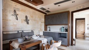 A modern kitchen with a stone wall, wooden beams, and a built-in island with a sink.