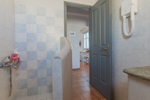 A bathroom with a shower, a toilet, a sink, and a towel rack.