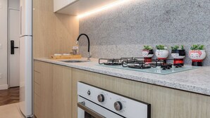 Una cocina moderna con armarios de madera, encimera de granito, horno empotrado y cocina a gas.