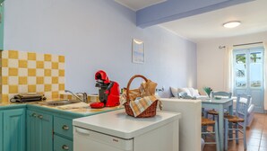 A kitchen with a Bosch dishwasher, a red coffee machine, and a checkered backsplash.