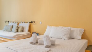 Een hotelkamer met een bed, kussens en opgerolde handdoeken.