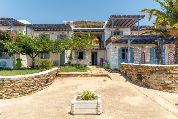 A traditional Mediterranean-style building with stone walls, a courtyard, and a wooden pergola.