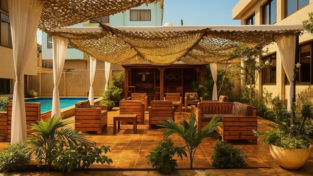 A poolside area with wooden furniture, a covered seating area, and a pool. - La Résidence Therésia LRT (Lomé)