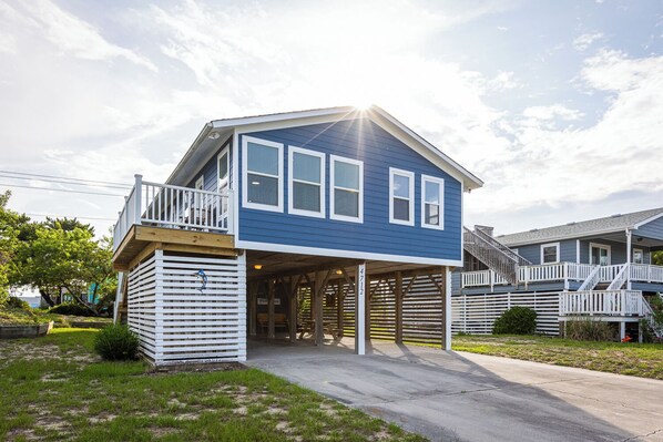 A two-story house with a covered garage and a deck.