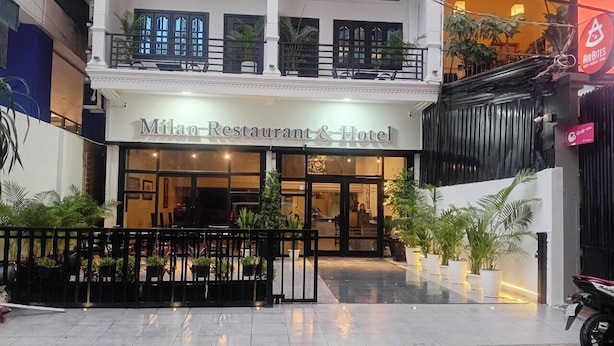 Het uiterlijk van Restaurant & Hotel Milan, met een hek, plantenbakken en een zichtbaar balkon.