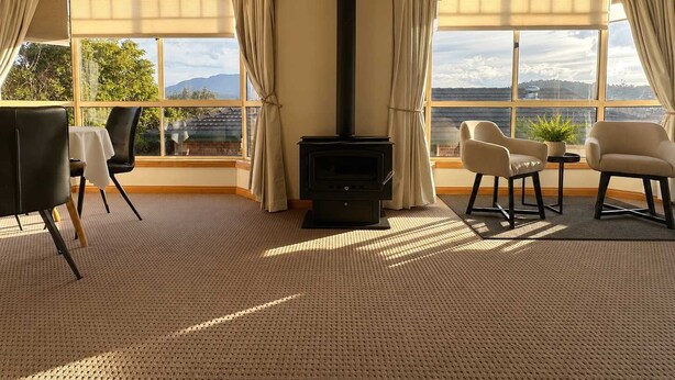 Una habitación con chimenea, ventanas amplias y vistas al exterior.