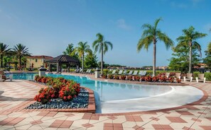A swimming pool with lounge chairs, a gazebo, and palm trees. - South-Facing Splash Pool • Resort Amenities • Gated • 7 Miles to Disney (Kissimmee)