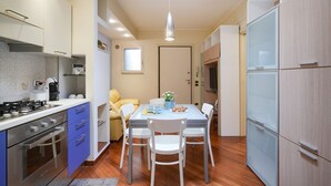 A compact kitchen with a dining area, a stove, and a refrigerator. - GuestHost - Comfortable 64 sqm apartment, able to accommodate up to 4 people, located on the ground floor of a building.The property is located in a semi-central area of ​​Bari, well served and well connected to the main points of interest of the cit (Bari)