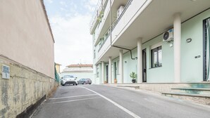 A street view of a building with a parking lot, a sign indicating reserved parking, and a clear sky. - Casa Gioia (Lucca)