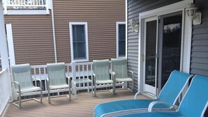 A covered outdoor deck with lounge chairs and a table. - Spacious 7BR + 6-Car Parking | 2 Blocks from Beach (Bethany Beach)