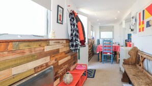 A cozy interior with a wooden wall, a dining area with a red tablecloth, and a bench.