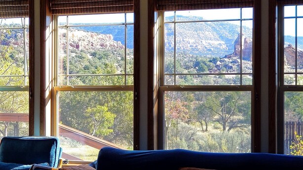 A room with large windows offering views of a mountainous landscape.