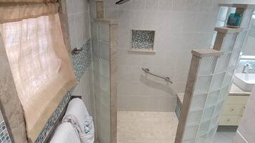 Chuveiro, secador de cabelo, toalhas de banho, papel higiênico