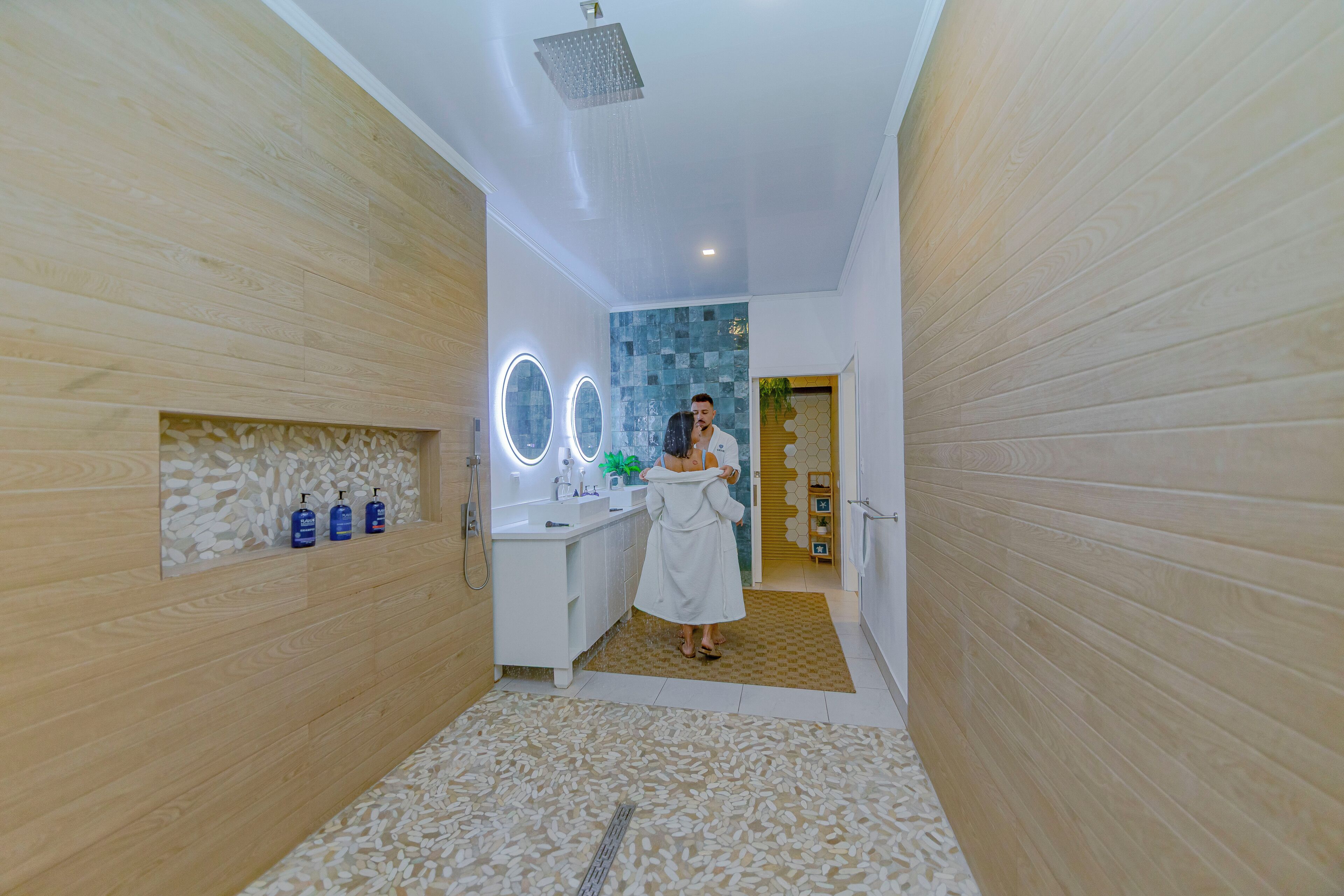 A modern bathroom with a shower, vanity, and a mirror with circular lights.