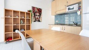 Una cocina moderna con armarios de madera, un microondas y una mesa de comedor con sillas.