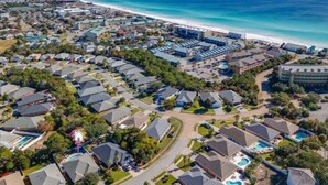 Een kustgebied met huizen, een strand en een groot hotelcomplex.