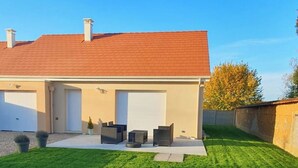A two-story house with a red-tiled roof, a garage, and a well-maintained lawn. - My little house: out of sight, out of mind (Acquigny)