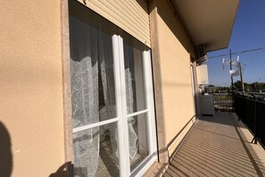 Un balcon d’où l’on peut admirer le ciel, avec un bâtiment en arrière-plan.