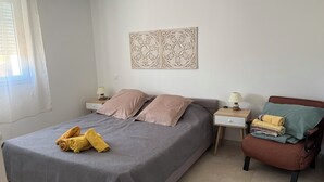 A neatly arranged bedroom with a bed, two nightstands, a chair, and a decorative wall piece.