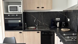 A modern kitchen with a microwave, oven, dishwasher, and stove.