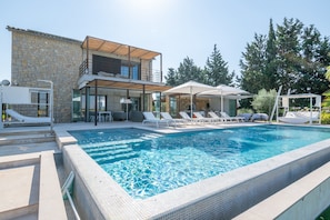 A modern house with a swimming pool, lounge chairs, and a covered patio area. - Elegant and Modern Villa Son Set with Heated Pool, Football Field, Wi-Fi and A/C (Inca)