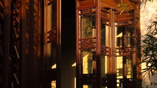 A traditional wooden door with intricate carvings and a glass panel. - Wu Suo · Li Ziyuan (Lijiang Old Town Mufu Hotel) (Lijiang)