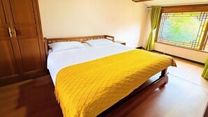 A room with a bed, wooden wardrobe, and a window with curtains. - Wu Suo · Li Ziyuan (Lijiang Old Town Mufu Hotel) (Lijiang)