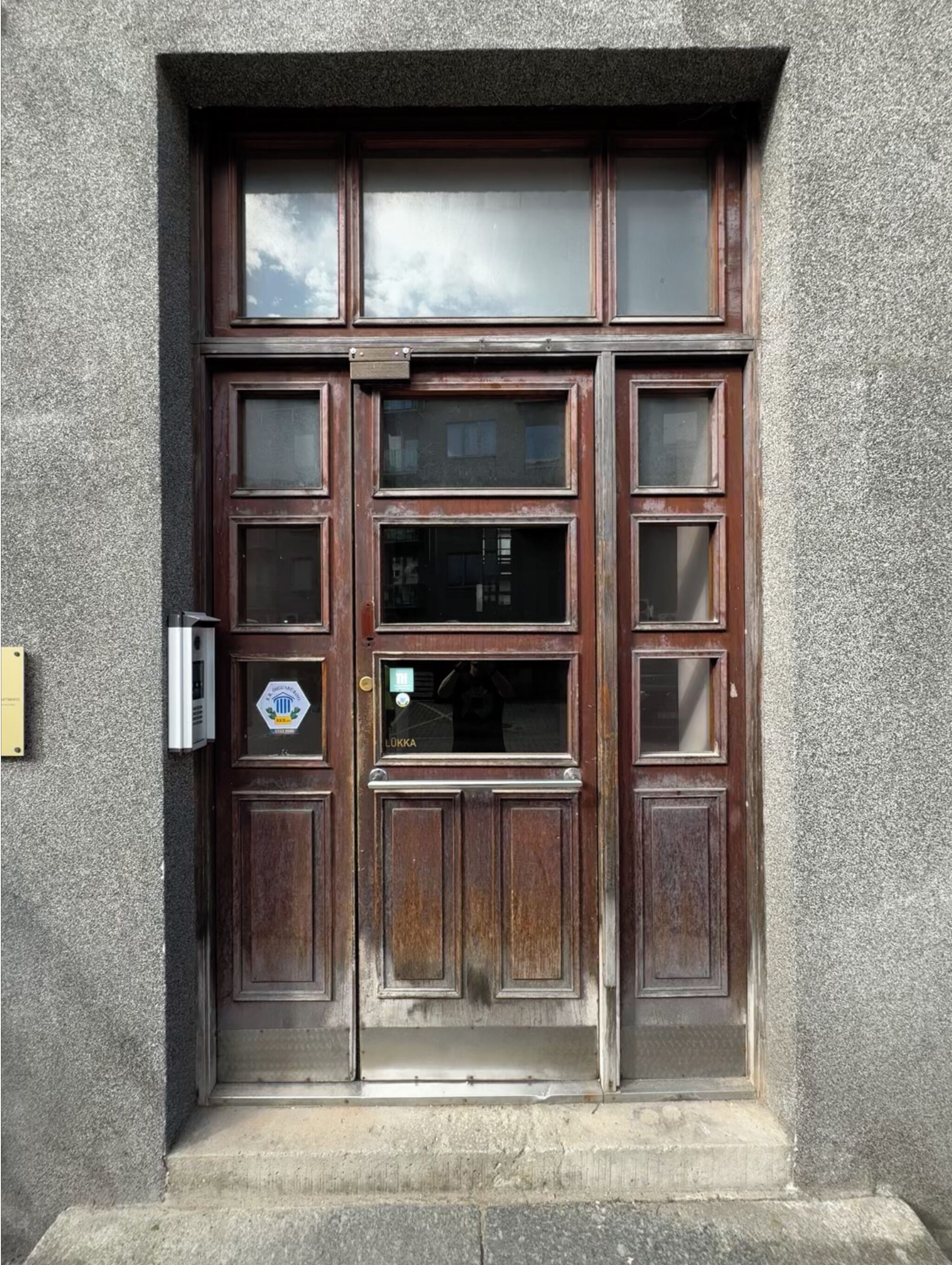 A wooden door with multiple panels and a small window.