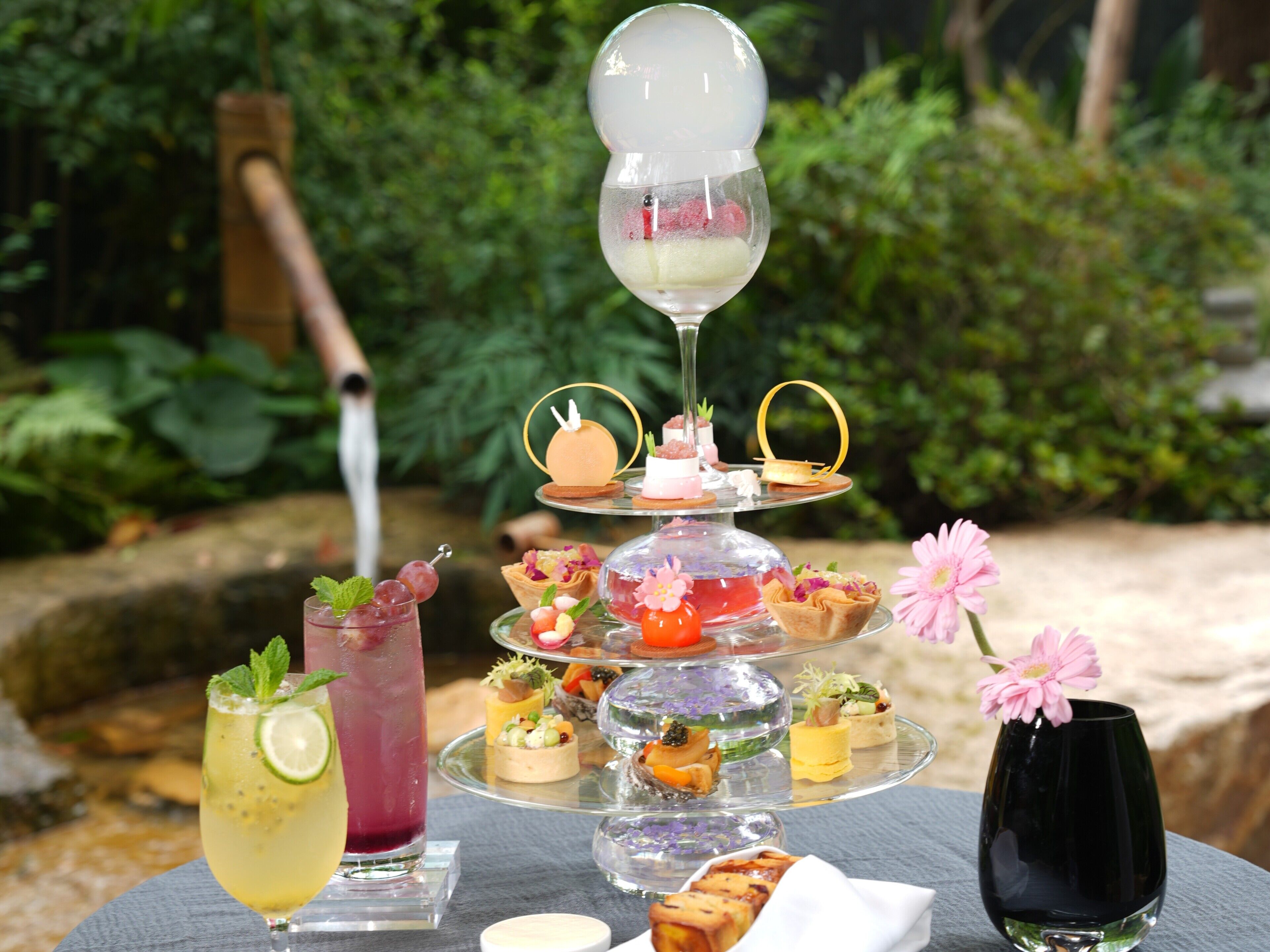 A glass table with a variety of food items and a drink.