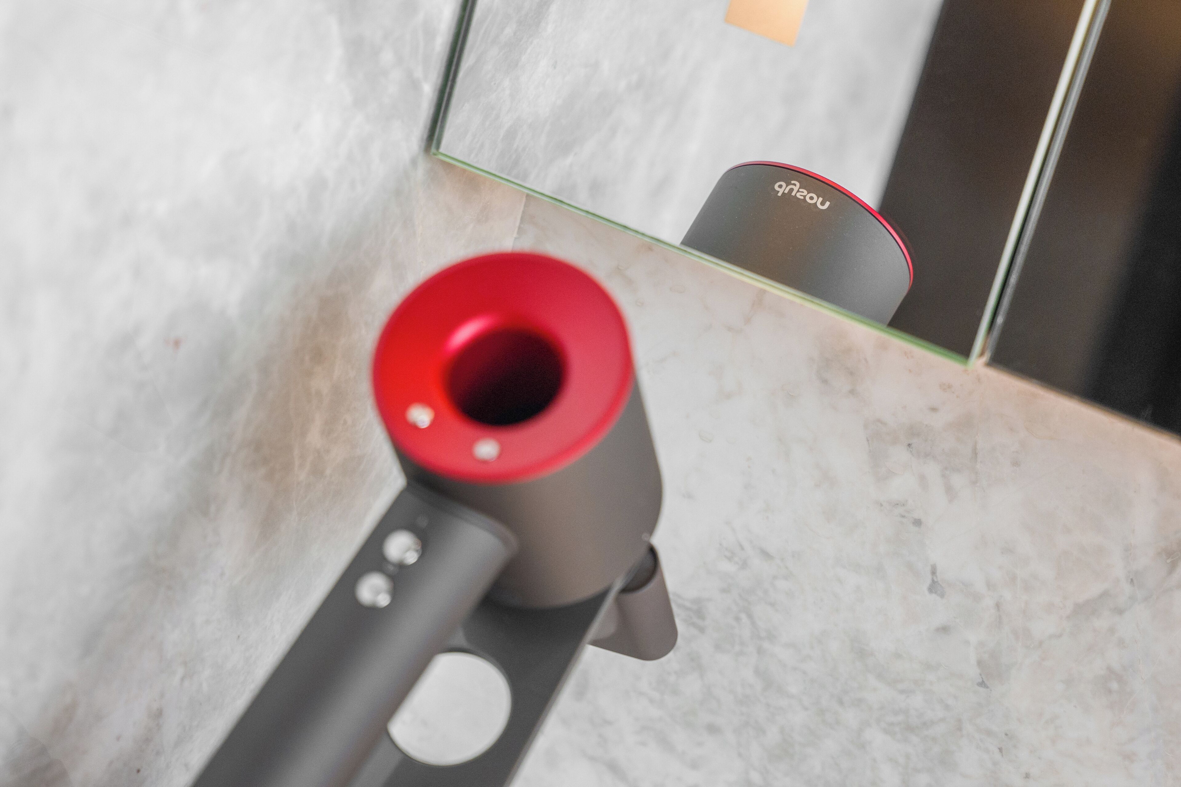 A close-up of a red object with a reflective surface, possibly a part of a larger item.