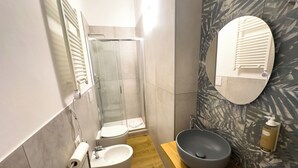 A bathroom with a glass shower enclosure, a toilet, a sink with a basin, and a mirror. - SWEET HOME COSSERIA (Florence)