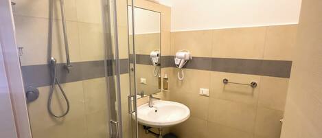 A modern bathroom with a glass-enclosed shower, a sink, and a towel rack.