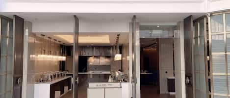 Una cocina moderna con una isla central, armarios con puertas de vidrio y un techo alto.