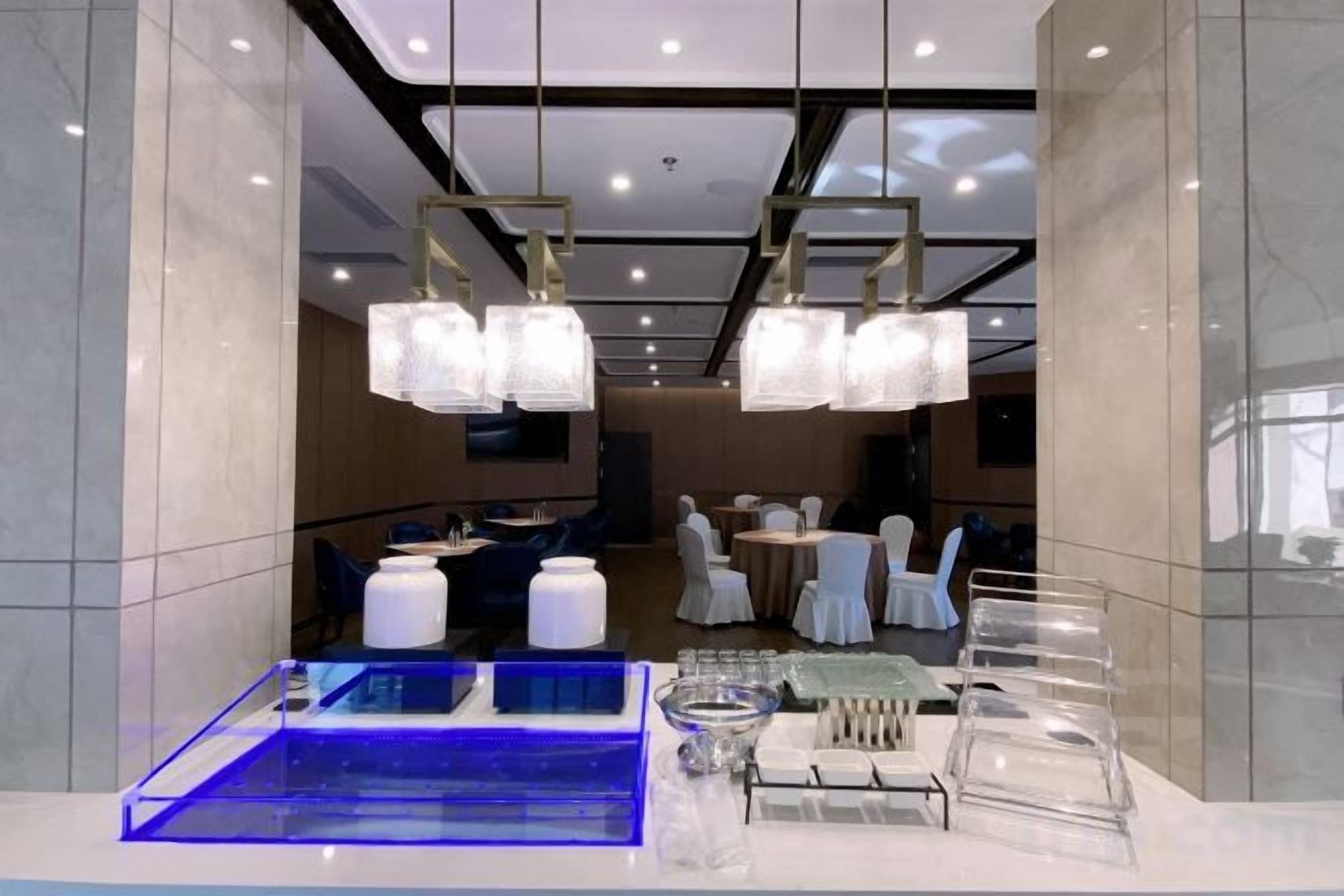 Un hall de hotel con mostrador de recepción, zona de estar y comedor.