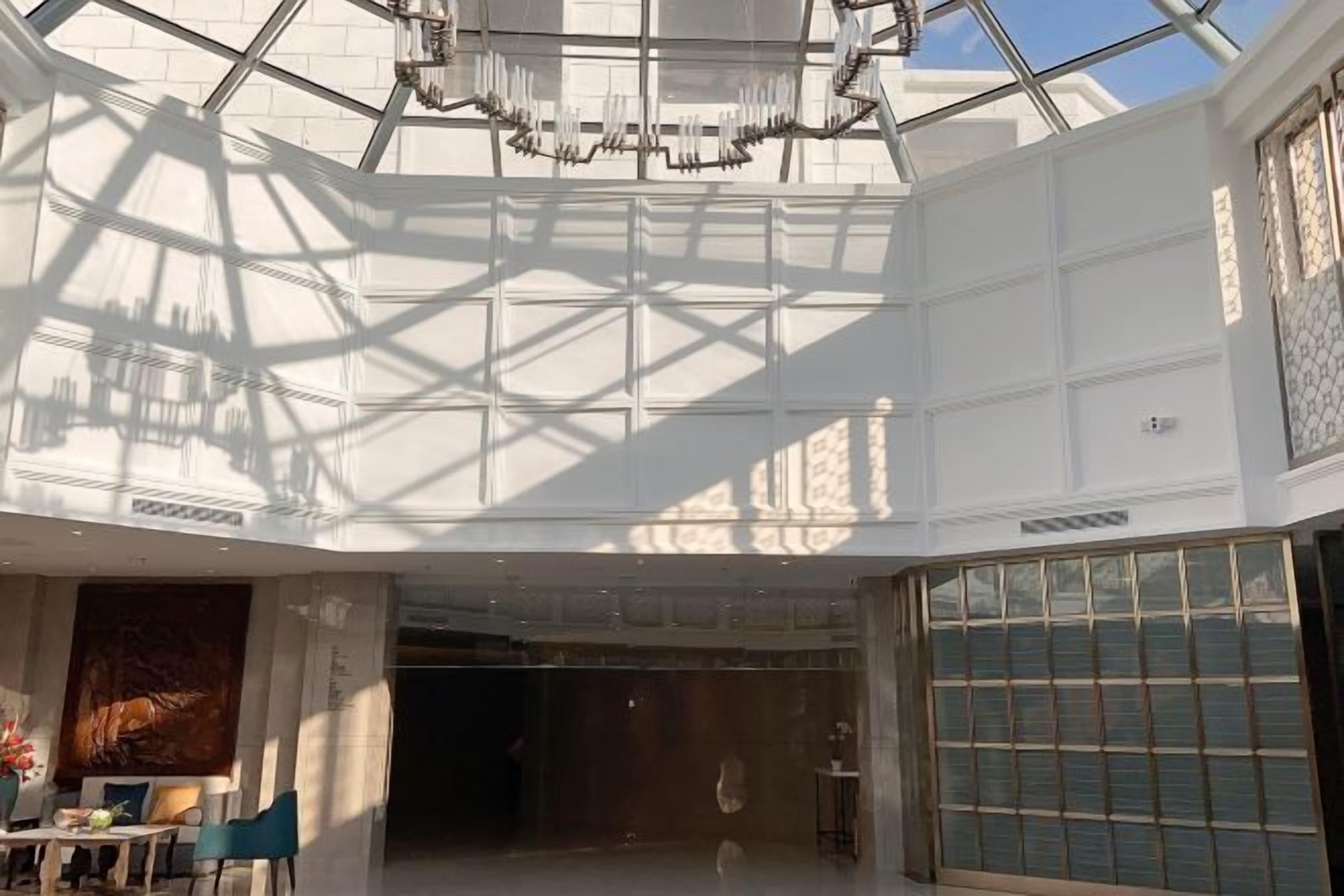 Un interior espaiós amb un sostre alt, grans finestres i un penjall.