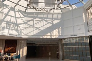 A spacious interior with a high ceiling, large windows, and a chandelier. - Dongshan Hotel (Anshan)