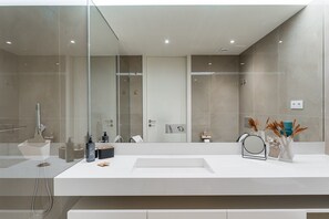 A modern bathroom with a large mirror, a white sink, and a glass shower enclosure. - GuestReady - Beautiful getaway in Gaia (Vila Nova de Gaia)