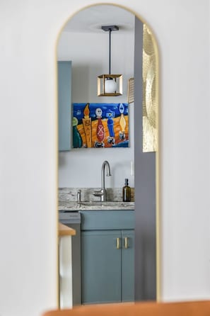 Una cocina con un armario azul, un lavamanos y una lámpara colgante.