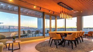 A modern interior with a large table, chairs, and a view through large windows. - STUDENT EXPERIENCE MADRID POZUELO (Pozuelo de Alarcon)