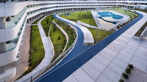 A modern building with a curved design, a central courtyard with a pool, and a surrounding walkway. - STUDENT EXPERIENCE MADRID POZUELO (Pozuelo de Alarcon)
