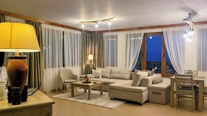 A modern living room with a sofa set, a coffee table, a lamp, and a dining area with a table and chairs.