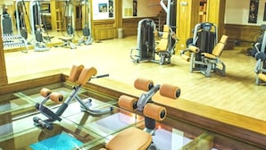 A gym with exercise equipment, a glass floor, and a wooden floor.