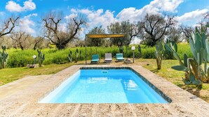 A rectangular swimming pool with a wooden pergola and two lounge chairs in the background. - Trullo Puspo by Wonderful Italy (Carovigno)