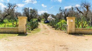 A dirt path leading to a building with a sign reading "Casa de Campo." - Trullo Puspo by Wonderful Italy (Carovigno)