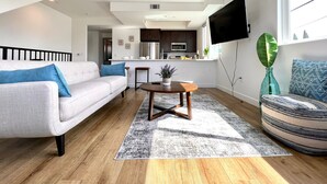 A modern living room with a sofa, a coffee table, and a patterned rug. - Truly Special LA Gem private rooftop deck VIEWS (Los Angeles)