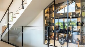 Un intérieur moderne avec une balustrade en verre, un escalier et un présentoir à vin.