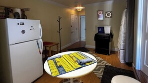 A compact living space with a kitchenette, a dining table with a mat, and a small seating area. - Large Private Level 2-bedroom Garden en-suite San Francisco (San Francisco)