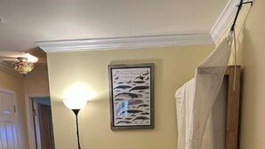A small room with a wooden floor, a white door, a ceiling fan, a framed picture on the wall, and a small table with two yellow stools. - Large Private Level 2-bedroom Garden en-suite San Francisco (San Francisco)