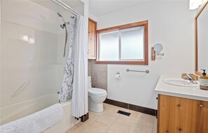 A bathroom with a bathtub, toilet, and sink.